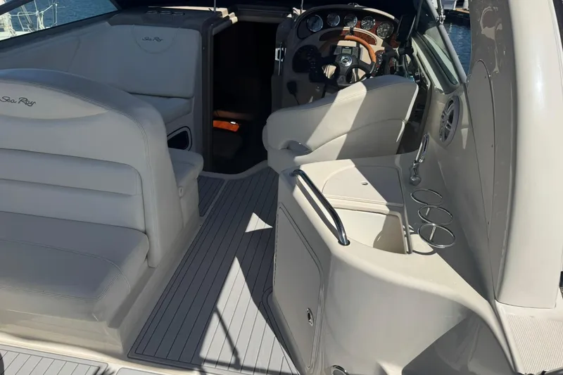 Slide: The Image of 2005 Sea Ray 280 Sundancer interior with helm, seating, and cup holders. - 23
