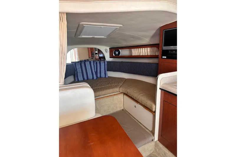 Slide: The Image of Interior of 2005 Sea Ray 280 Sundancer boat with cozy seating and striped cushions. - 27