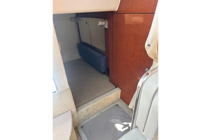 Slide: The Image of Interior cabin of 2005 Sea Ray 280 Sundancer with wood paneling and carpeted flooring. - 28