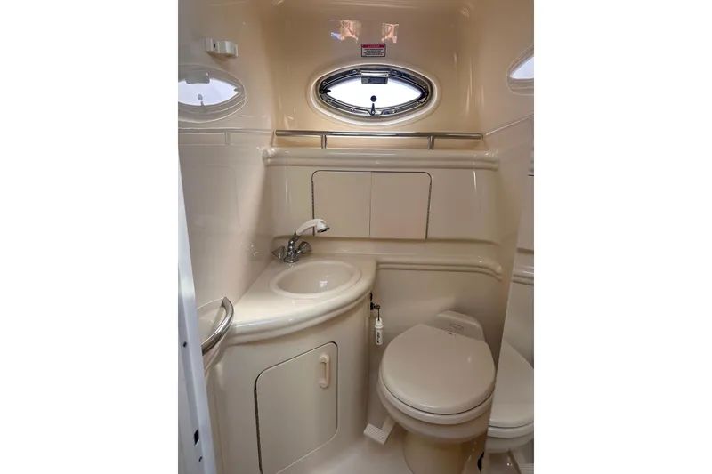 Slide: The Image of 2005 Sea Ray 280 Sundancer bathroom with sink, toilet, and porthole window. - 32