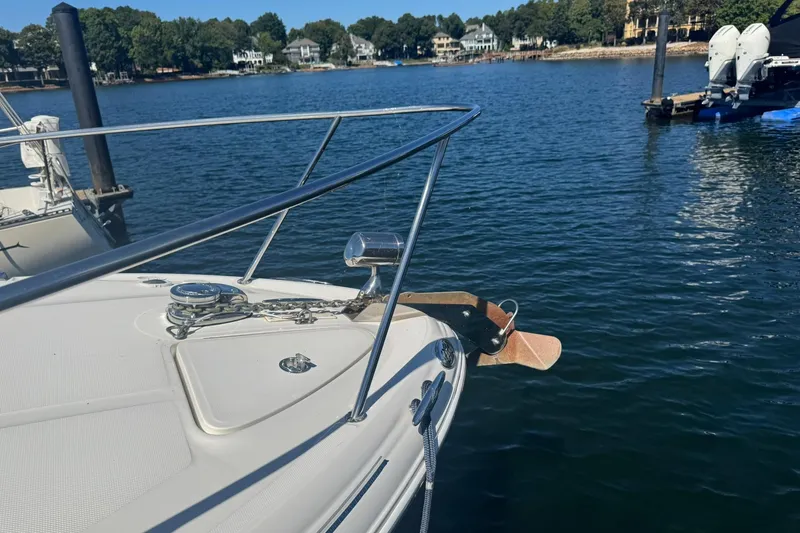 Slide: The Image of 2005 Sea Ray 280 Sundancer bow with anchor, docked on a serene lake. - 8
