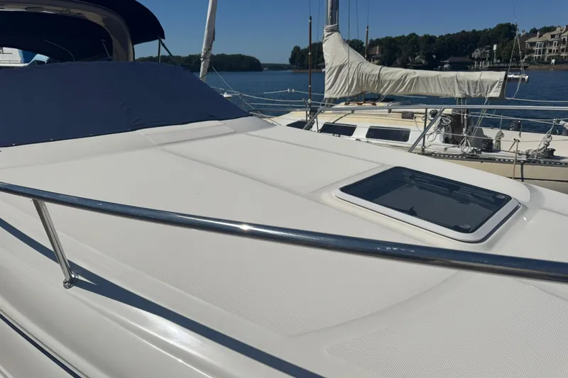 Slide: The Image of 2005 Sea Ray 280 Sundancer boat docked, featuring sleek deck design and hatch. - 9