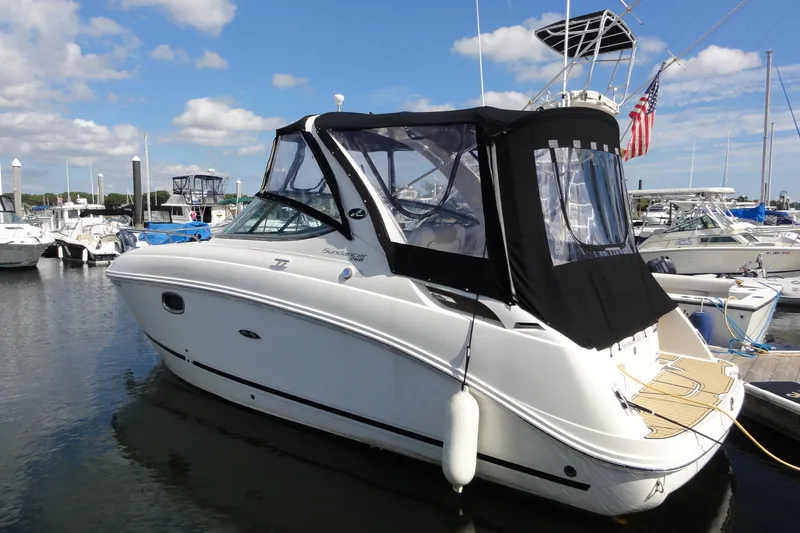 The Image of 2010 Sea Ray 260 Sundancer boat docked in a marina under a partly cloudy sky. - 0