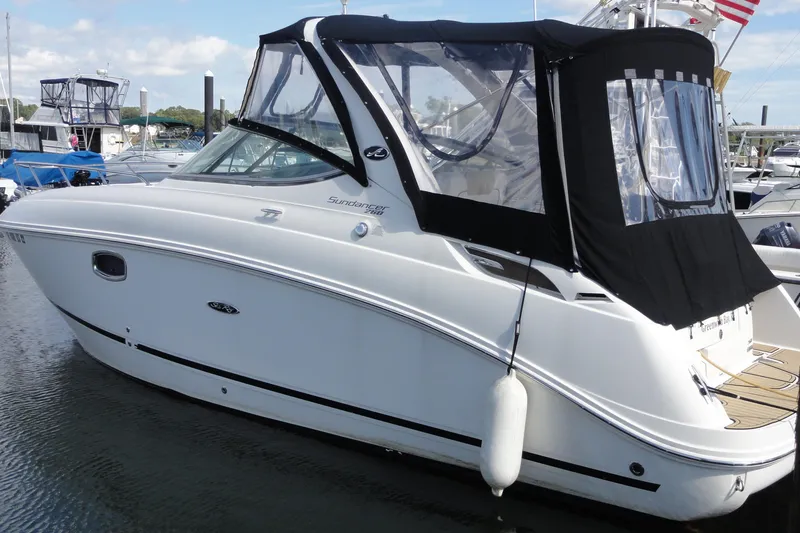 Slide: The Image of 2010 Sea Ray 260 Sundancer boat docked with black canopy in marina. - 19