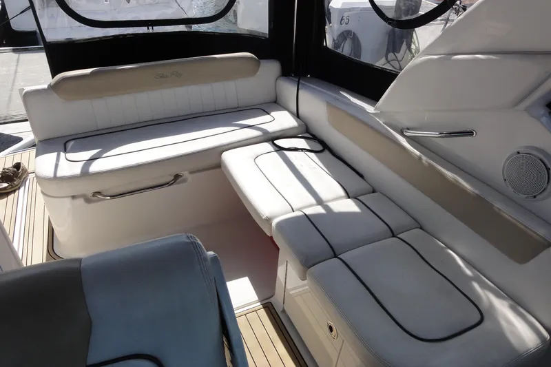 Slide: The Image of Interior seating of 2010 Sea Ray 260 Sundancer boat, featuring white cushioned seats. - 5