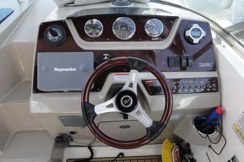 Slide: The Image of Control panel of a 2010 Sea Ray 260 Sundancer boat with steering wheel and gauges. - 6