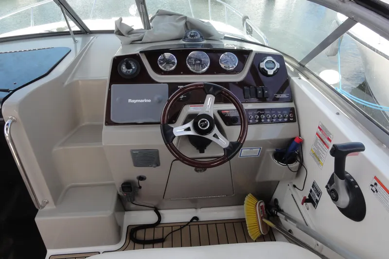 Slide: The Image of 2010 Sea Ray 260 Sundancer helm with steering wheel and control panel. - 8
