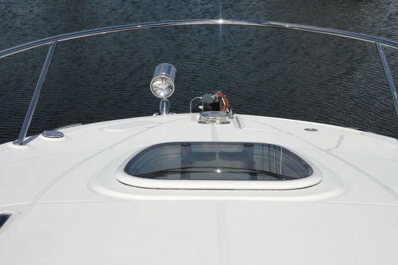 Slide: The Image of 2010 Sea Ray 260 Sundancer boat deck with hatch and spotlight on calm water. - 9