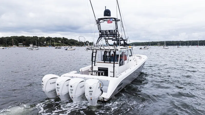 Slide: The Image of 2017 Everglades 435 CC boat with four engines cruising on a lake. - 14