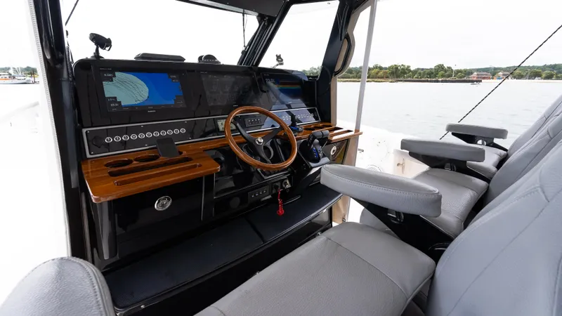 Slide: The Image of 2017 Everglades 435 CC boat cockpit with modern navigation equipment and comfortable seating. - 29