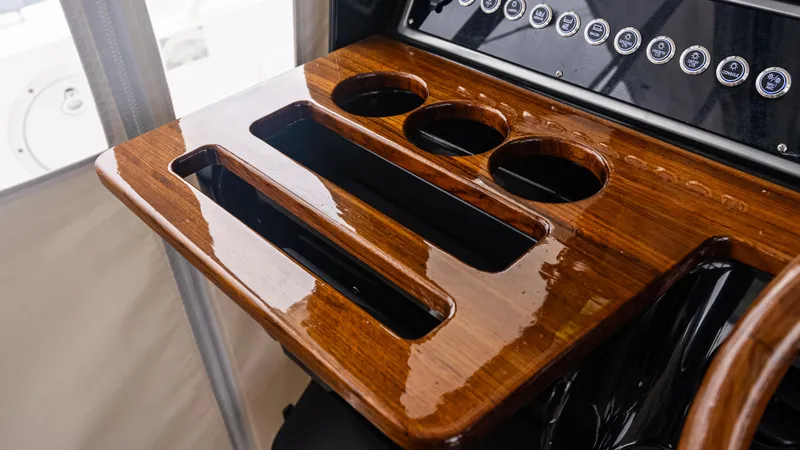 Slide: The Image of Polished wooden console with cup holders on 2017 Everglades 435 CC boat. - 31
