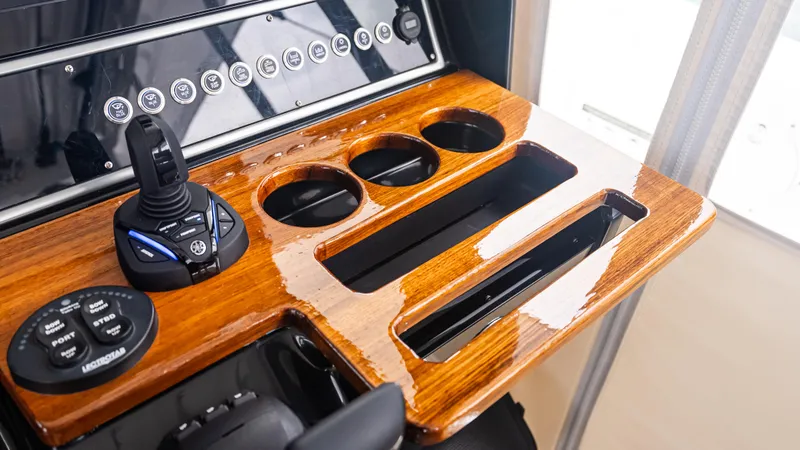 Slide: The Image of Control panel of 2017 Everglades 435 CC boat with joystick and cup holders. - 32