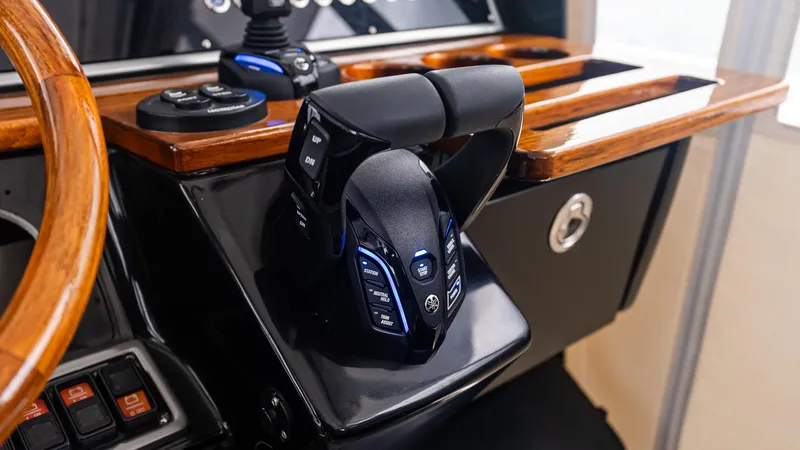 Slide: The Image of Throttle controls on a 2017 Everglades 435 CC boat dashboard with wood accents. - 33