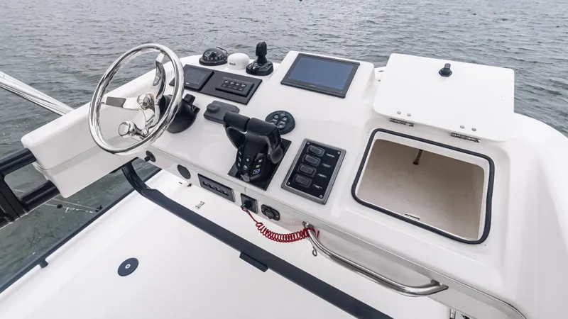 Slide: The Image of Control panel of a 2017 Everglades 435 CC boat, featuring steering wheel and navigation equipment. - 38