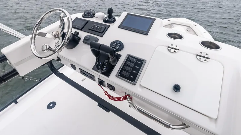 Slide: The Image of Control panel of 2017 Everglades 435 CC boat with steering wheel and navigation equipment. - 39