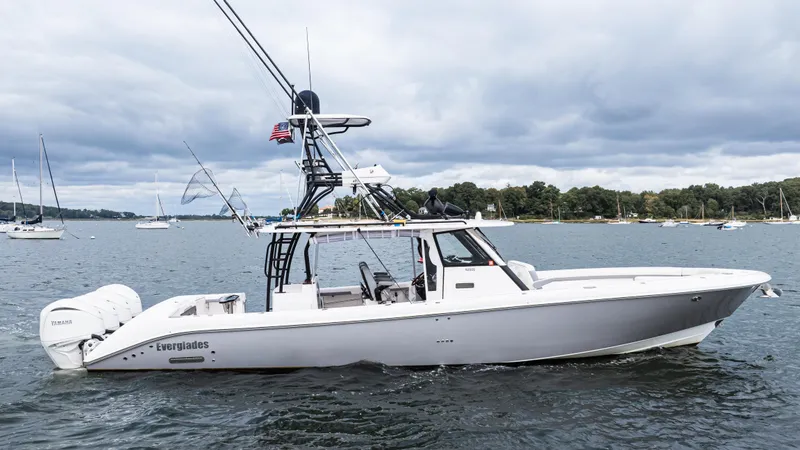 Slide: The Image of 2017 Everglades 435 CC boat on water, with fishing rods and American flag. - 4
