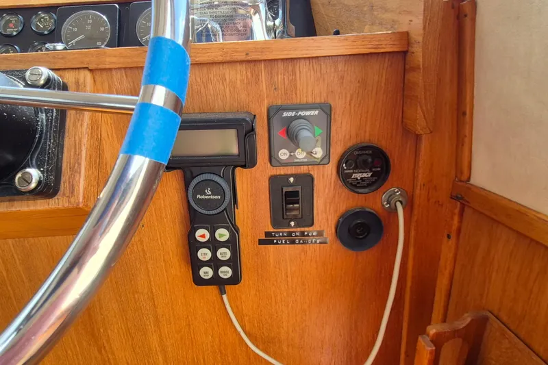 Slide: The Image of Control panel of a 1990 Sabreline 36 Fast Trawler with steering wheel and navigation instruments. - 15
