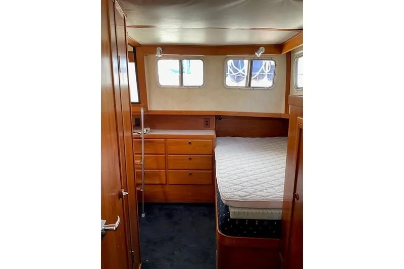 Slide: The Image of 1990 Sabreline 36 Fast Trawler cabin with bed, wooden drawers, and windows. - 26