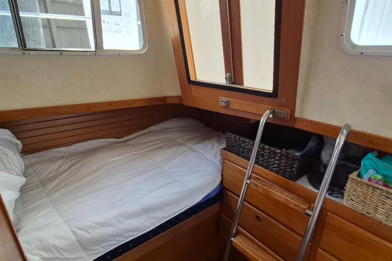 Slide: The Image of Cozy cabin interior of 1990 Sabreline 36 Fast Trawler with bed and storage. - 30