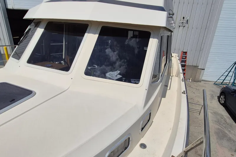Slide: The Image of 1990 Sabreline 36 Fast Trawler docked, showcasing cabin windows and deck details. - 49