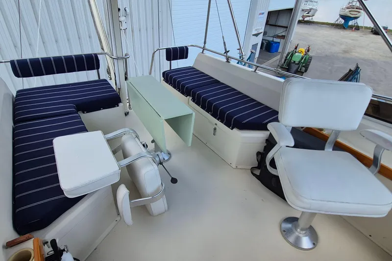 Slide: The Image of Interior of 1990 Sabreline 36 Fast Trawler with striped seating and white chairs. - 55