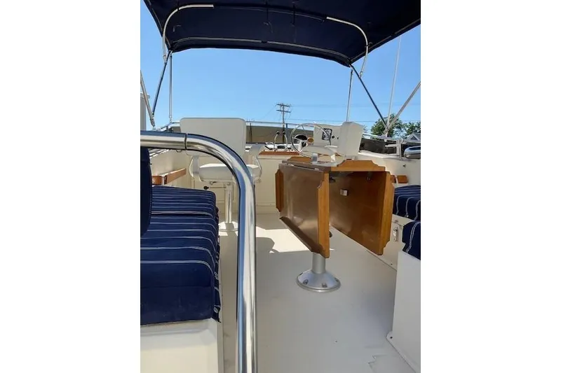 Slide: The Image of 1990 Sabreline 36 Fast Trawler interior with blue-striped seating and wooden table. - 64