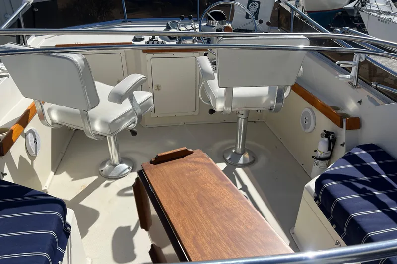 Slide: The Image of 1990 Sabreline 36 Fast Trawler cockpit with helm, seating, and wooden table. - 65
