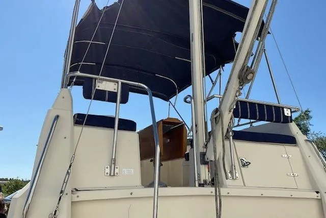 Slide: The Image of 1990 Sabreline 36 Fast Trawler, rear view with canopy and seating, clear sky background. - 66
