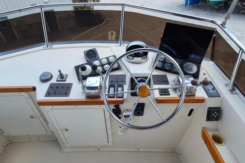 Slide: The Image of 1990 Sabreline 36 Fast Trawler helm with steering wheel and navigation controls. - 76