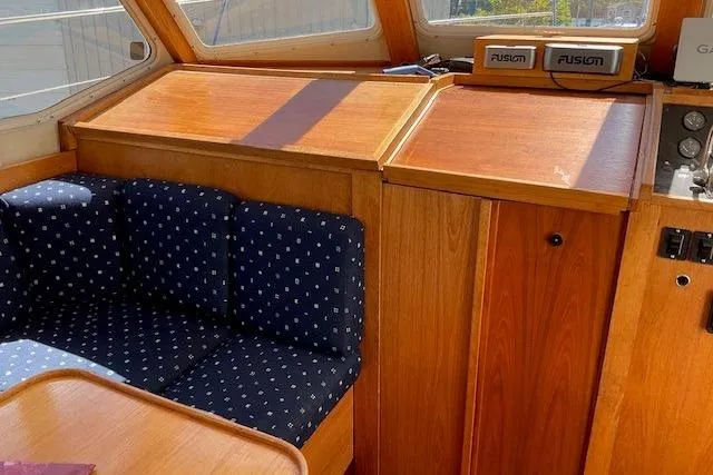 Slide: The Image of Interior of 1990 Sabreline 36 Fast Trawler with wood finish and blue cushioned seating. - 11