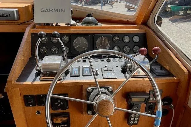 Slide: The Image of 1990 Sabreline 36 Fast Trawler helm with Garmin navigation and classic wooden dashboard. - 12