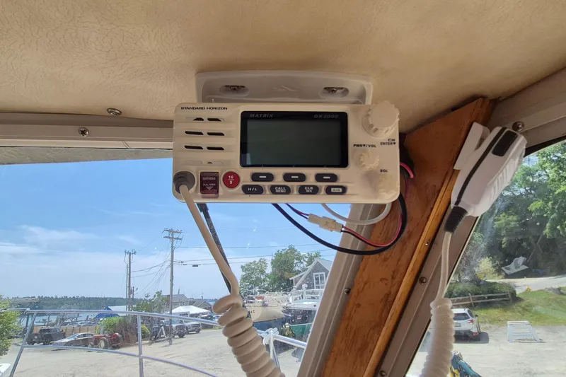 Slide: The Image of VHF radio on 1990 Sabreline 36 Fast Trawler, docked with scenic marina view. - 16