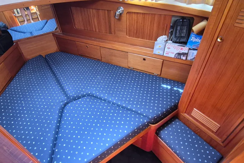 Slide: The Image of 1990 Sabreline 36 Fast Trawler cabin with blue polka dot bedding and wooden storage. - 17