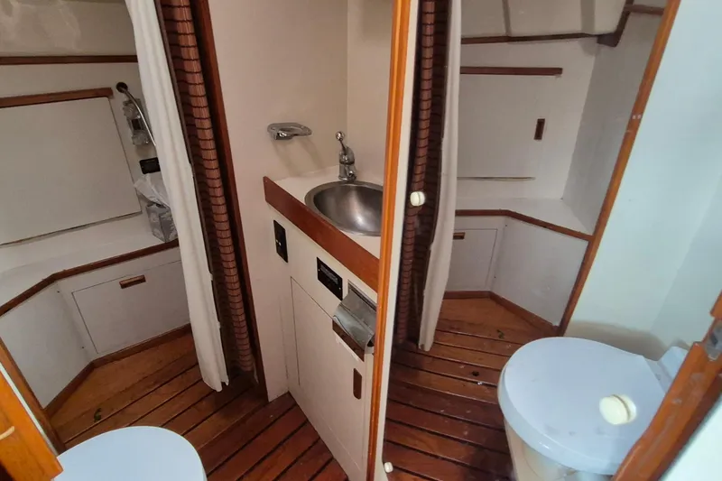Slide: The Image of 1990 Sabreline 36 Fast Trawler bathroom with sink, toilet, and wooden flooring. - 22