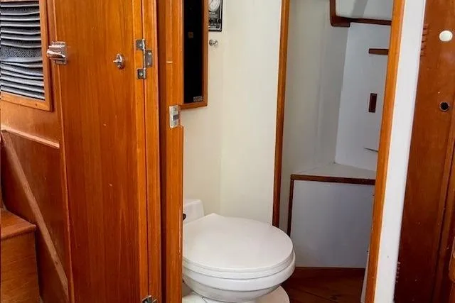 Slide: The Image of 1990 Sabreline 36 Fast Trawler bathroom with wooden interior and compact toilet. - 23
