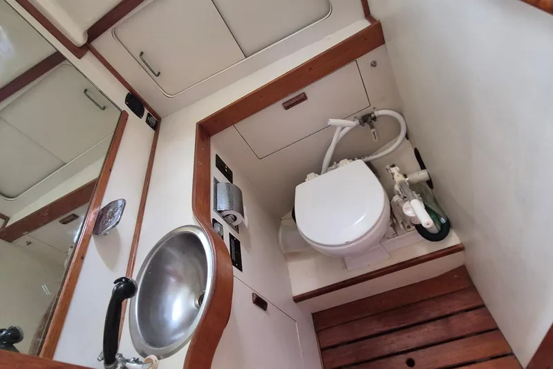 Slide: The Image of 1990 Sabreline 36 Fast Trawler bathroom with sink, toilet, and wooden flooring. - 24