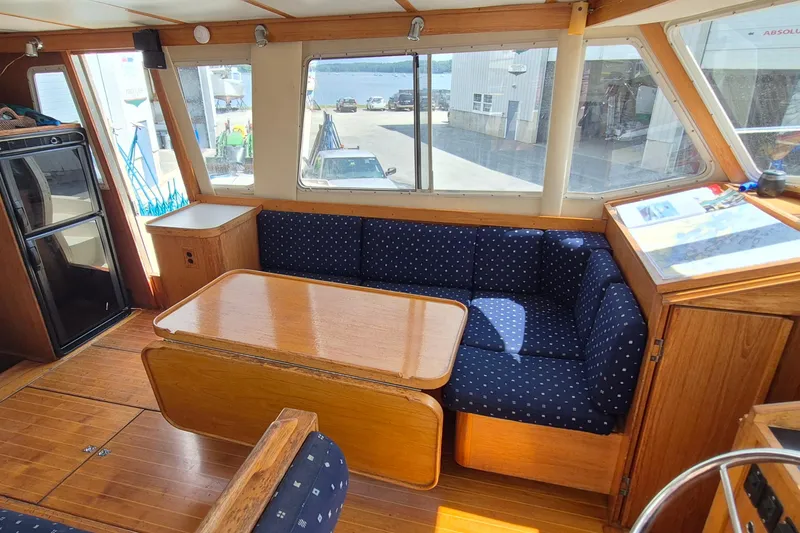 Slide: The Image of Interior of 1990 Sabreline 36 Fast Trawler with blue cushioned seating and wooden table. - 3