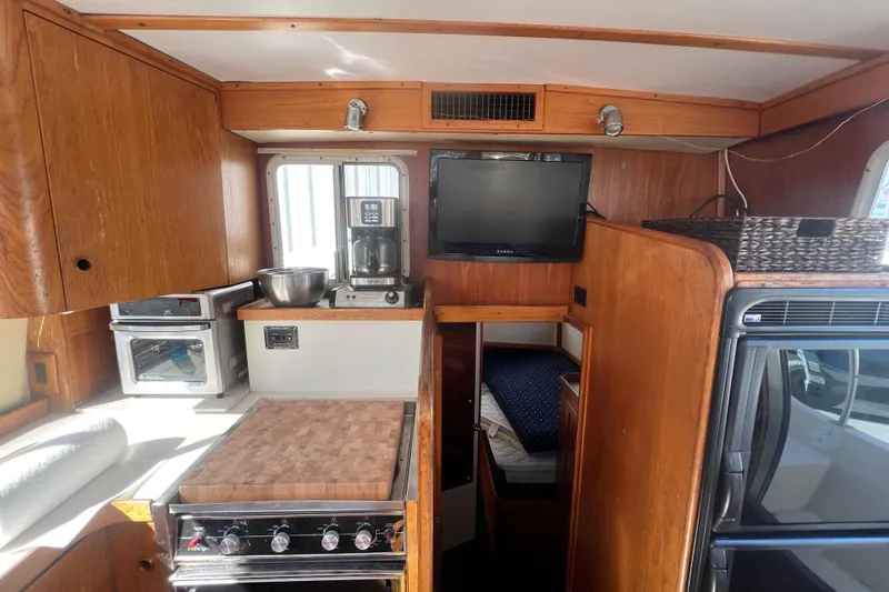 Slide: The Image of 1990 Sabreline 36 Fast Trawler interior with kitchen, TV, and cozy cabin space. - 37