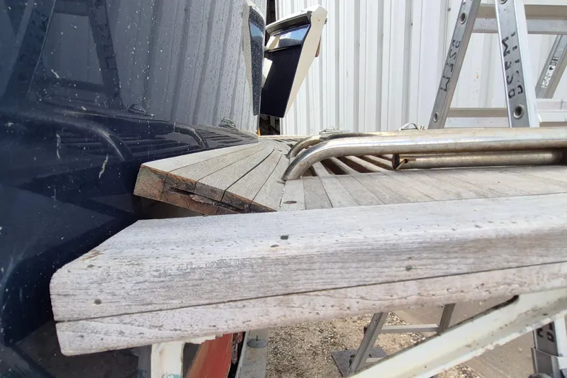 Slide: The Image of 1990 Sabreline 36 Fast Trawler with wooden deck and metal railings, docked near a ladder. - 47