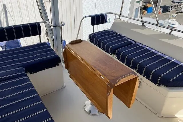 Slide: The Image of 1990 Sabreline 36 Fast Trawler interior with striped seating and wooden table. - 60