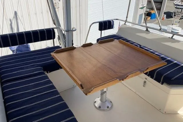 Slide: The Image of 1990 Sabreline 36 Fast Trawler with striped seating and wooden table on deck. - 61