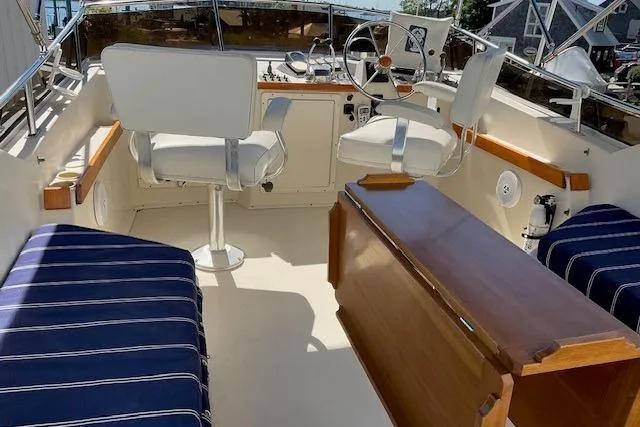 Slide: The Image of 1990 Sabreline 36 Fast Trawler cockpit with helm, seating, and wooden table. - 63