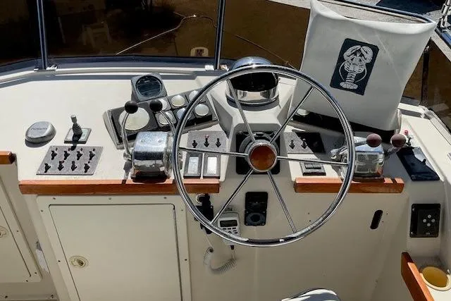 Slide: The Image of 1990 Sabreline 36 Fast Trawler helm with steering wheel and control panel. - 74