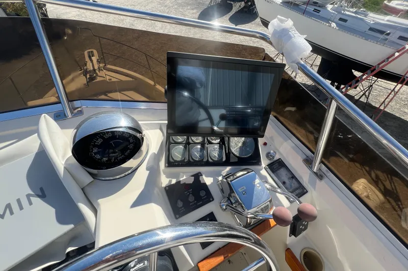 Slide: The Image of 1990 Sabreline 36 Fast Trawler helm with compass, navigation screen, and controls. - 79