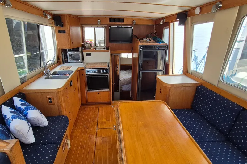 Slide: The Image of Interior of 1990 Sabreline 36 Fast Trawler with cozy seating and compact kitchen. - 9