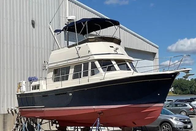 Slide: The Image of 1990 Sabreline 36 Fast Trawler docked, featuring a blue hull and spacious cabin. - 94
