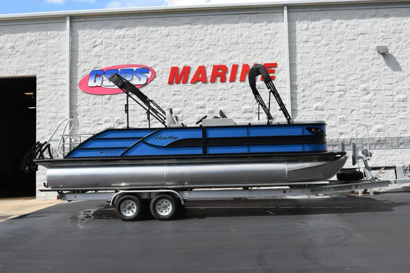 The Image of 2026 Bentley Pontoons Legacy 243 Swingback on trailer outside marine dealership. - 1