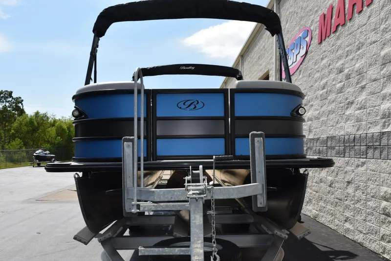 Slide: The Image of 2026 Bentley Pontoons Legacy 243 Swingback on trailer, parked outside dealership. - 3