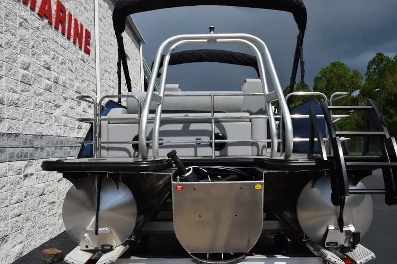 Slide: The Image of 2026 Bentley Pontoons Legacy 243 Swingback, rear view, parked near a building. - 5