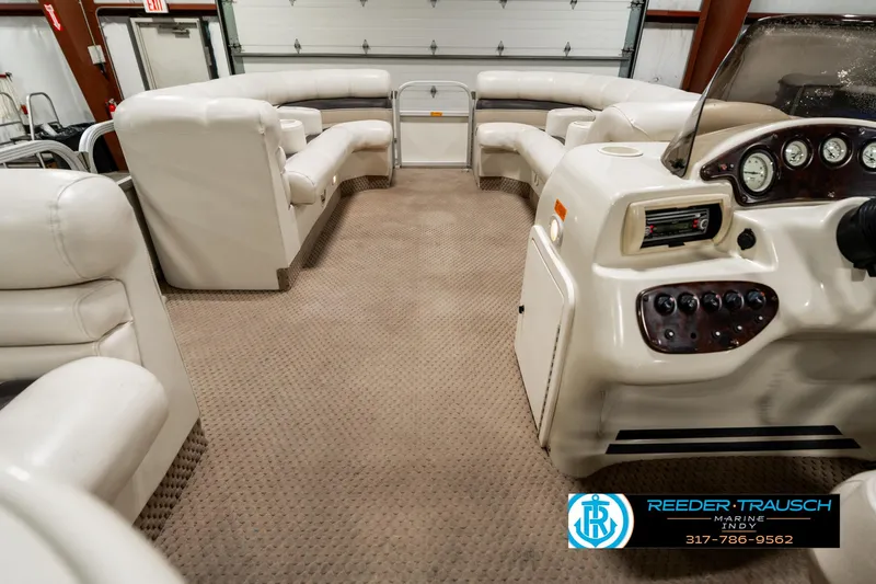 Slide: The Image of 2003 Bennington 2050 RL pontoon boat interior with plush seating in a spacious garage. - 20